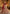 A woman models a traditional Indian lehenga choli outfit in an ornate palace corridor. The outfit features a deep red embroidered bodice and dupatta paired with a heavily embellished cream and red skirt.