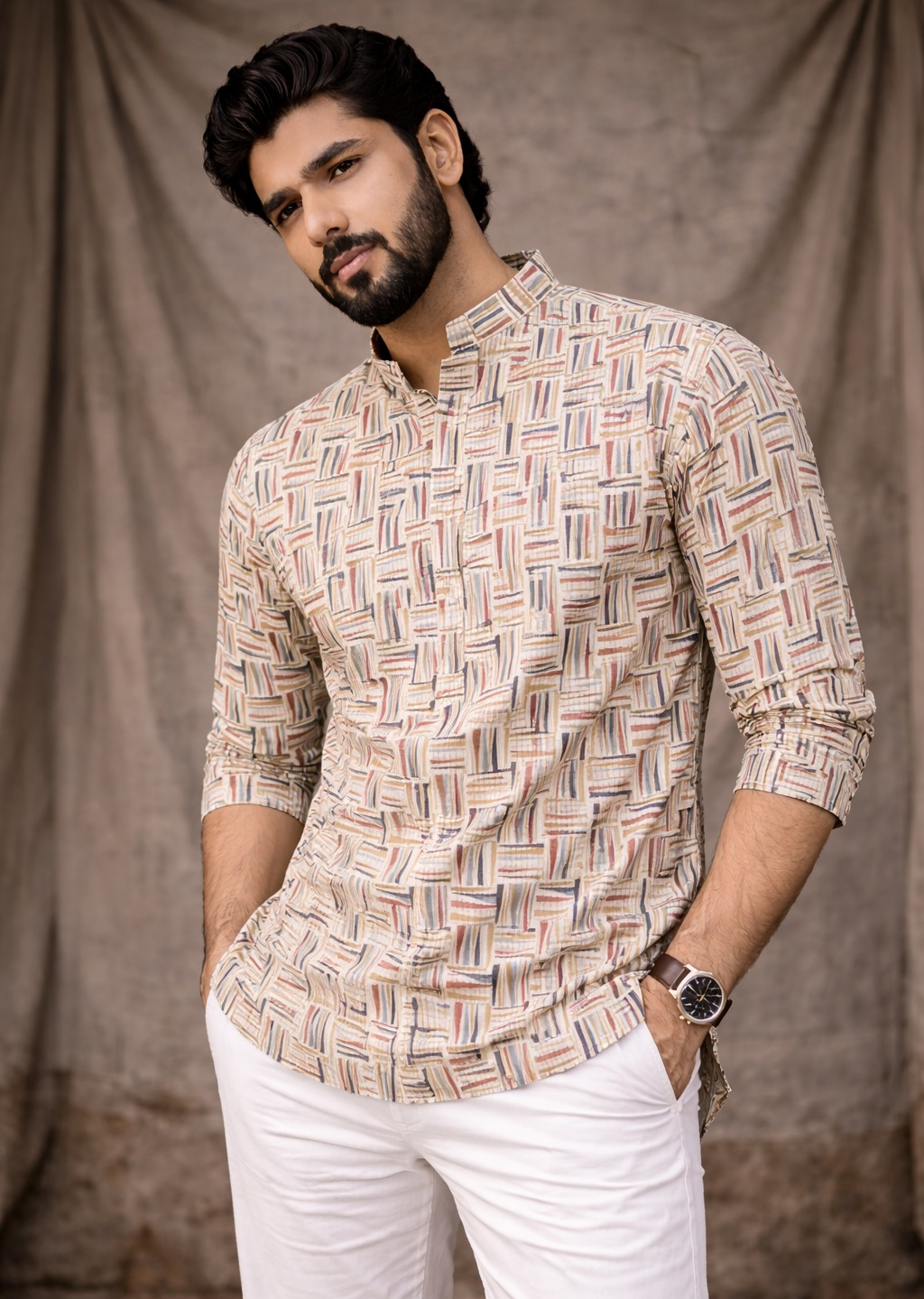 A man wearing a beige long-sleeve kurta with a multicolor geometric pattern,