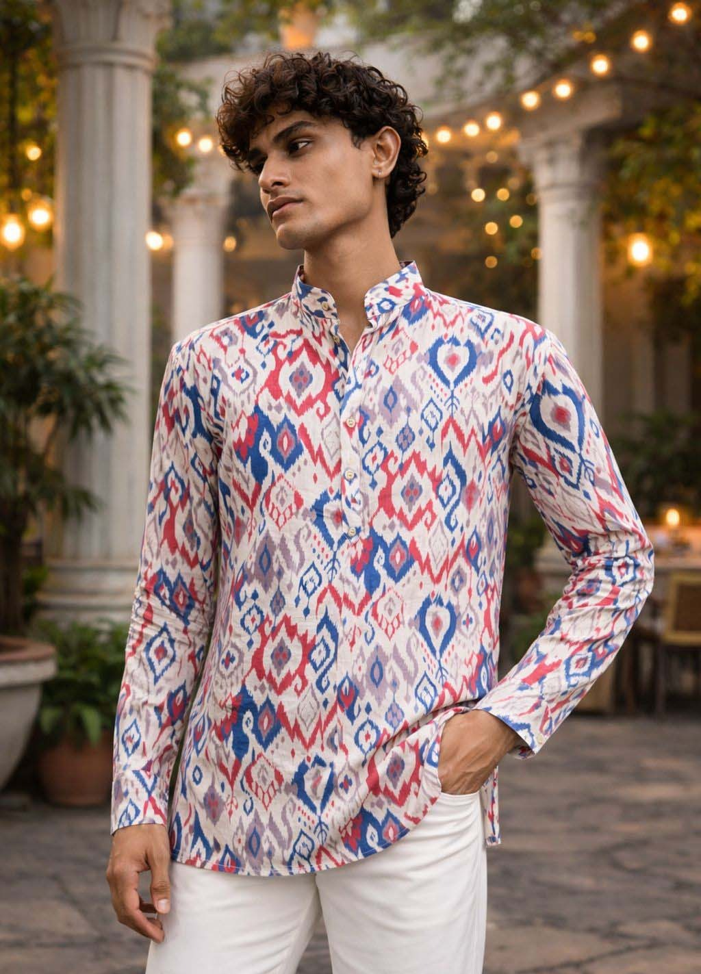 A man wearing a long-sleeve button-up shirt with a red, blue, and white ikat pattern.
